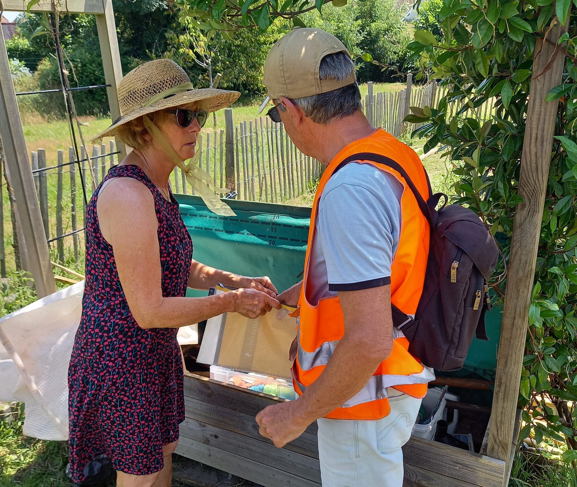 Patricia et Michel regardent le carnet de compte-rendu du potager